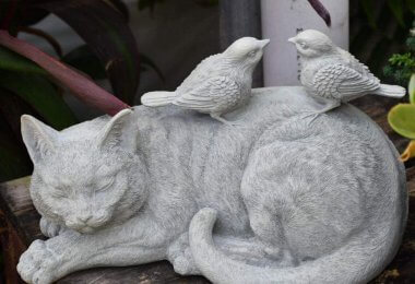 statue de chat avec des oiseaux